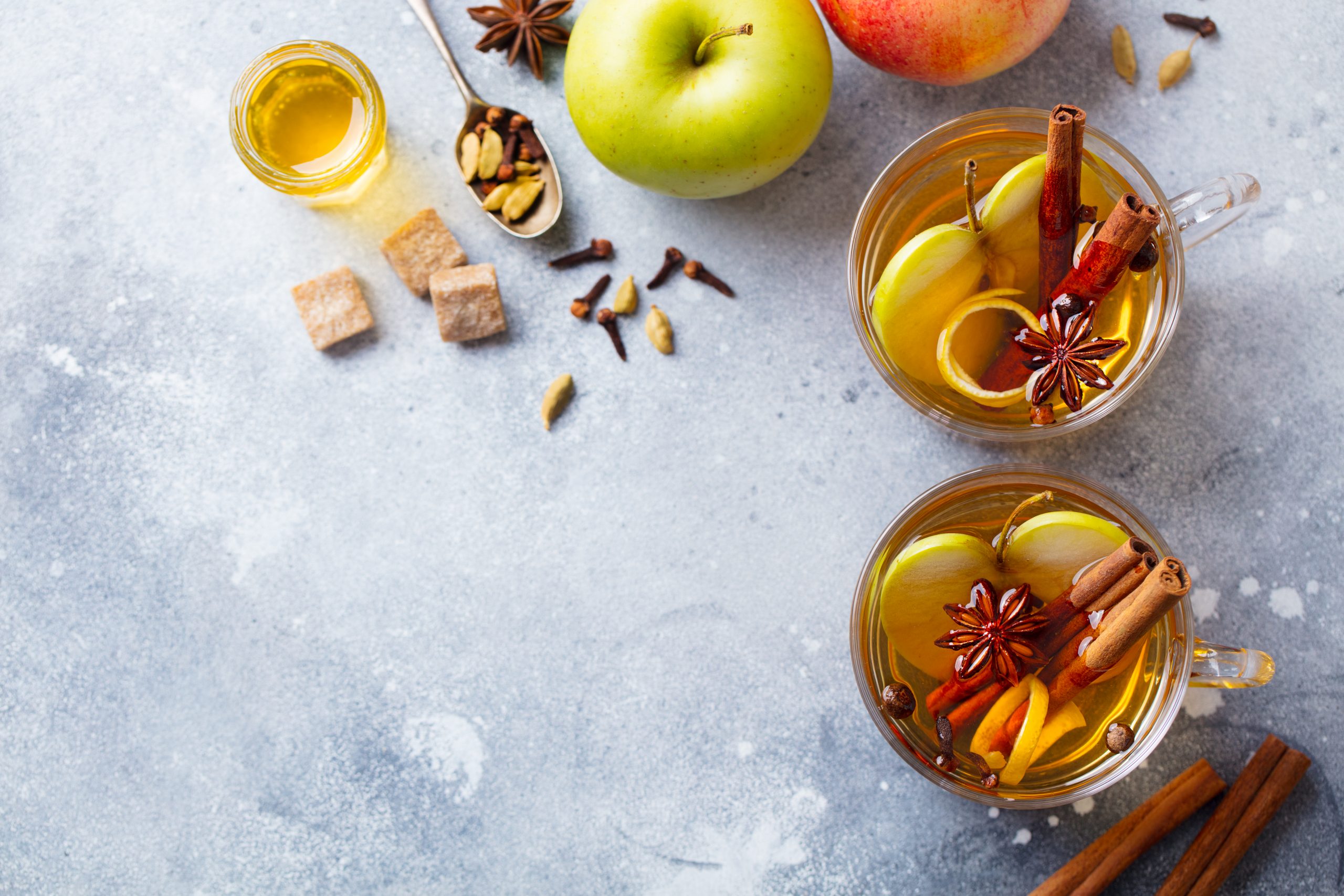 Apple,Mulled,Cider,With,Spices,In,Glass,Cup.,Grey,Stone